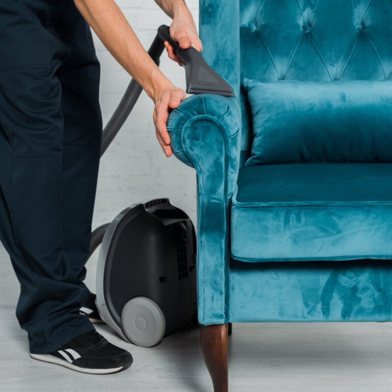 cropped view of cleaner dry cleaning blue armchair with vacuum cleaner